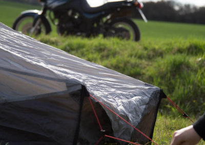 Der Zeltaufbau im Vordergrund, das Motorrad im Hintergrund